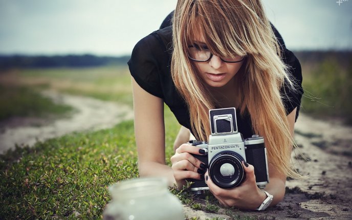 Blonde woman taking photos with a professional camera