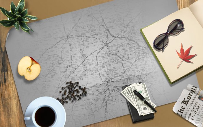 Stuff for a trip - coffee, money, sunglasses, notebook, map