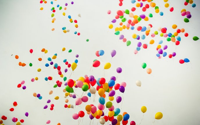 Hundreds of colorful balloons flying through the air