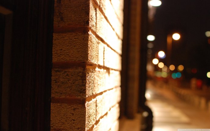 Brick wall close up - blurry street at night