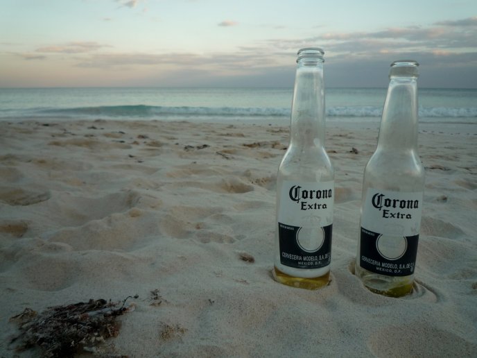 Two empty beer bottles on the beach