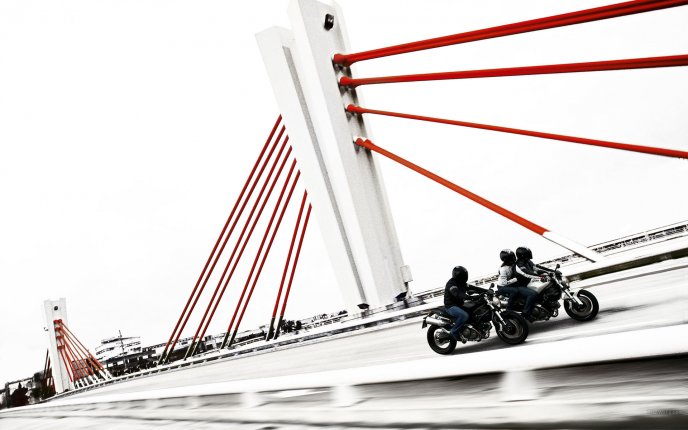 Motorcycles race on a bridge