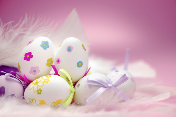 White eggs with beautiful drawings on the pink background