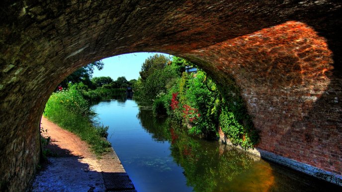 A river under an arched bridge - Nature wallaper