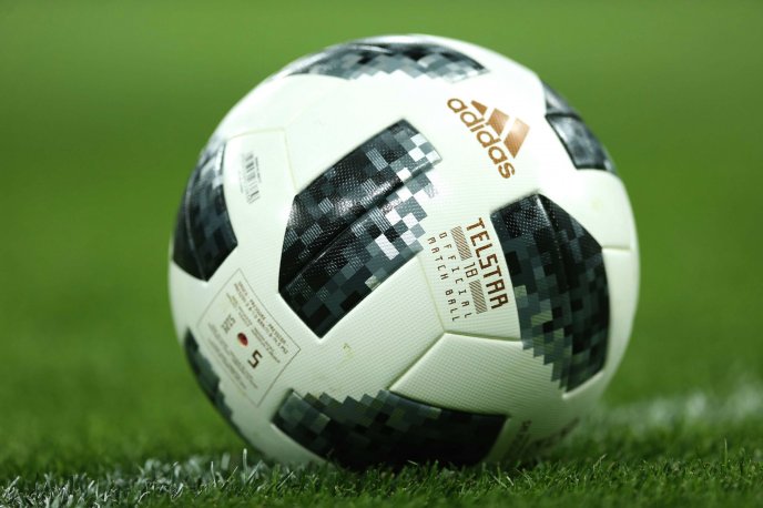 Macro football ball on the green field - Adidas sponsor FIFA