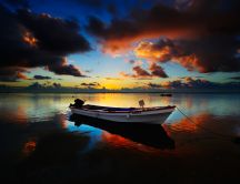 Anchored boat at sea at sunset