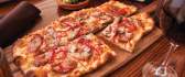 Delicious pizza on a wooden platter HD wallpaper