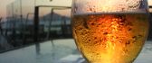 A glass of beer in front HD wallpaper