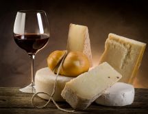 Different type of cheese and a glass of red wine
