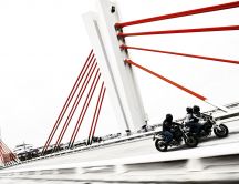 Motorcycles race on a bridge