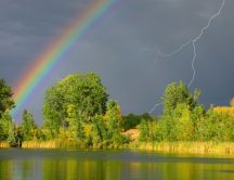 Rainbow and lightning on the dark sky