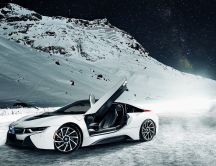 A white BMW I8 on the mountains with snow