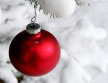 Beautiful red Christmas ball on a tree full with snow