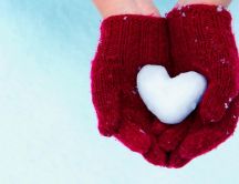 Red gloves and a wonderful heart made of snow