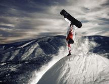Stay in one hand on the top of the mountain with snowboard