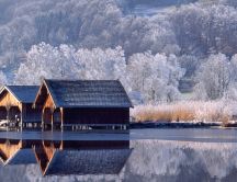 Two wooden house on the lake -View in the mirror winter time
