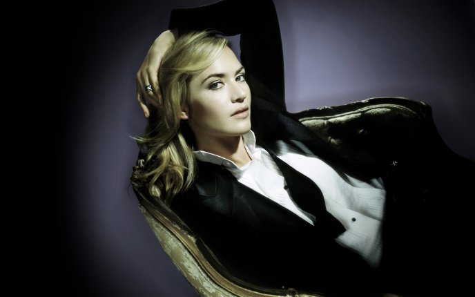Kate Winslet posing in an armchair