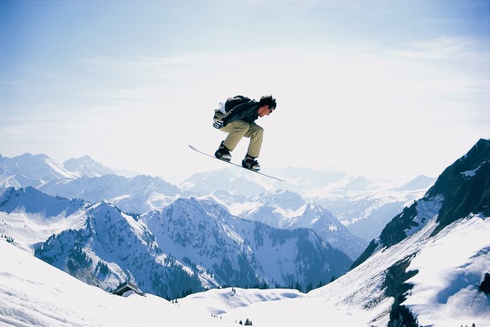Snowboard jump on the high summits of the mountains