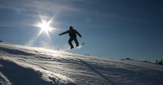 Snowboard jumping in sunlight HD wallpaper