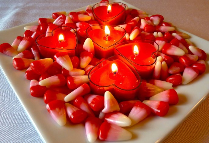 Heart shaped candles and jellies on a plate