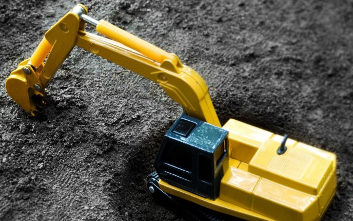 Funny wallpaper - toy excavator in a pit