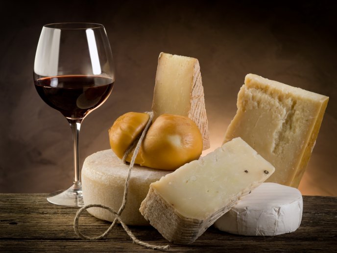 Different type of cheese and a glass of red wine