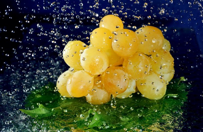 Fresh fruits - water drops over the yellow grapes
