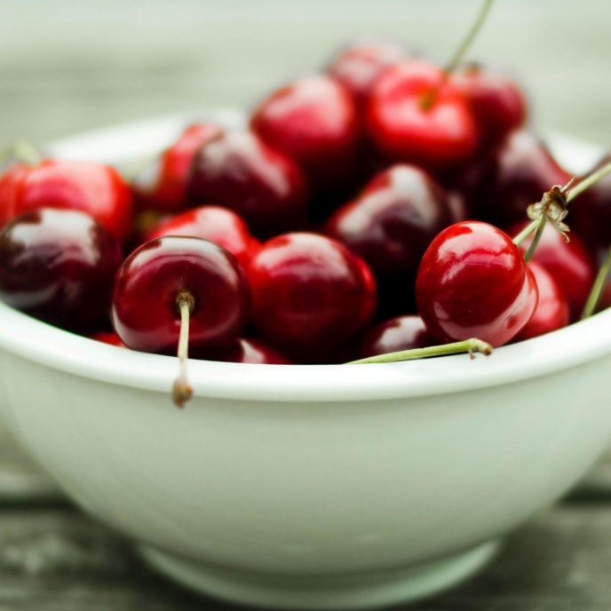 Shiny cherries in a white bowl - prepare for a movie