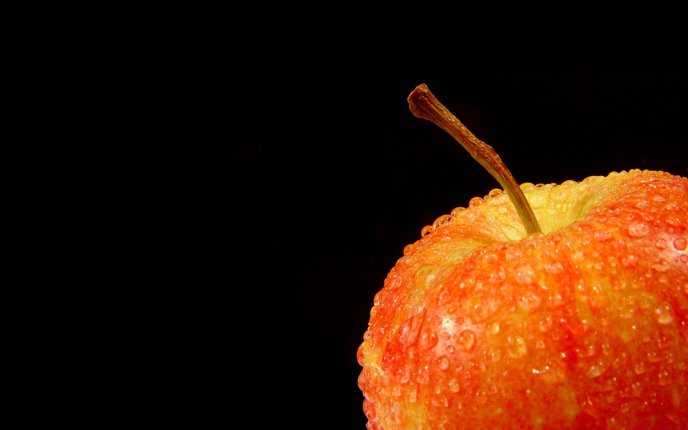 Big water drops on a red apple - HD black background