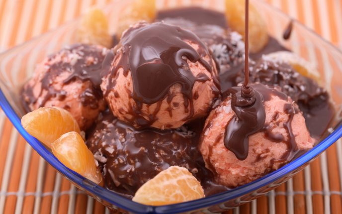 Delicious ice cream with chocolate topping and oranges