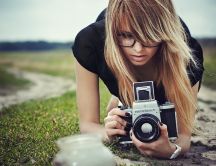 Blonde woman taking photos with a professional camera