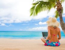 Girl on the beach with her laptop