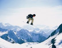Snowboard jump on the high summits of the mountains