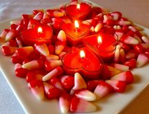 Heart shaped candles and jellies on a plate