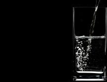 A glass with mineral water - dark background