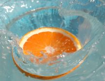 Slice orange splash in a glass of water