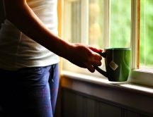 Girl with a green cup of hot tea - good morning sun