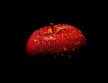 Red apple full with water drops in the dark