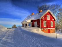 Red house and a beautiful white snow on the road