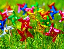 Colourful paper vanes in the green grass of spring