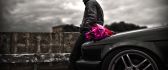 Romantic man waiting the perfect girl with flowers-Black car