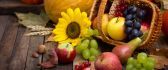 Basket full with delicious Autumn fruits-apples pears grapes